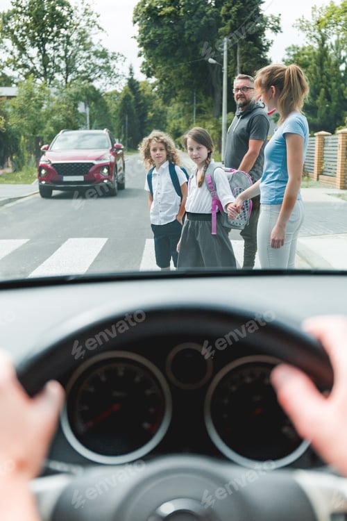Preview: Drivers point of view of family with children crossing a street on pedestrian area