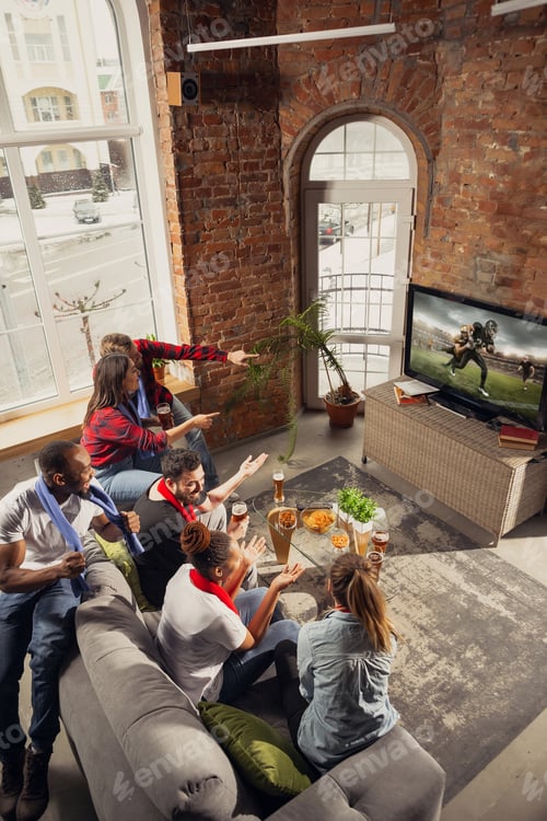 Preview: Excited group of people watching sport match at home