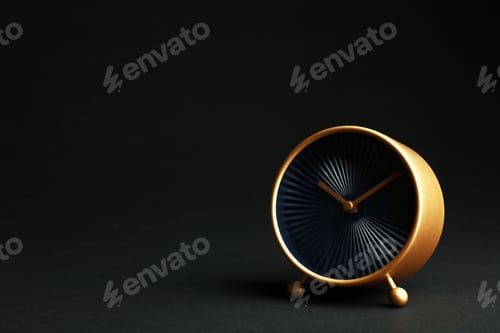 Preview: Golden alarm clock on black background. Space for text