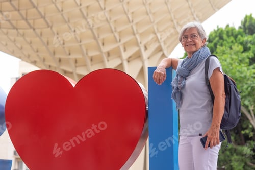 Preview: Attractive smiling senior woman on vacation in Seville, Spain, standing under the Setas