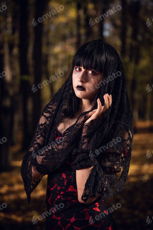Preview: Vertical shot of a Caucasian pretty female in a gothic style black dress