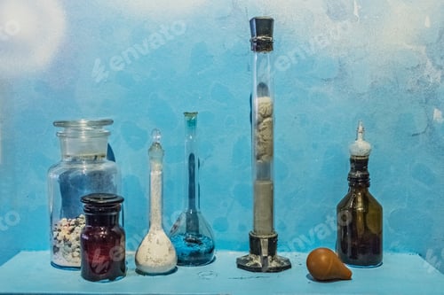 Preview: Laboratory bottles and test tubes with various contents on a shelf on a blue background