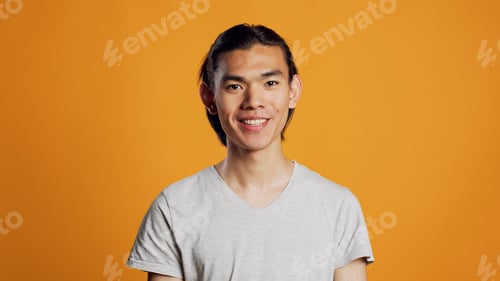 Preview: Cheerful smiling guy posing on orange background