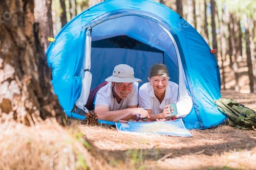 Preview: Couple Camping in Woods with Tent and Map