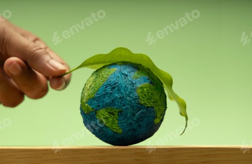 Preview: Hand putting Green leaf on Earth. Environmental sustainability, Earth Day, global care