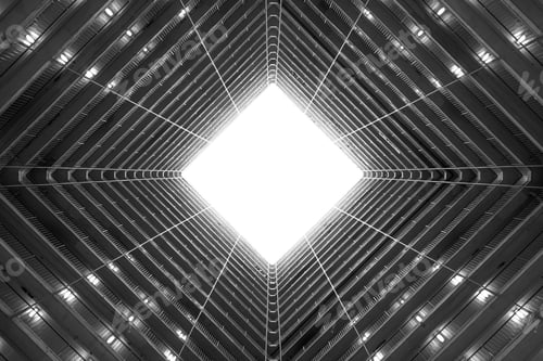 Preview: Greyscale low angle shot of the light coming in through the ceiling of a tall building