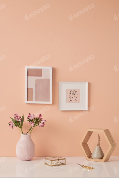 Preview: Two pictures in frames on pink wall by table with flowers in white ceramic vases