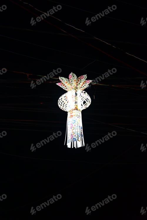 Preview: Vertical of a traditional lamp hanging on a ceiling in a dark room
