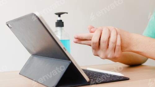 Preview: Asian woman using alcohol gel sanitizer wash hand before using tablet for protect coronavirus.