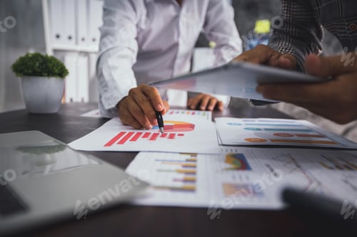 Preview: group of business people planning and analysis with financial graph paper and check in tablet