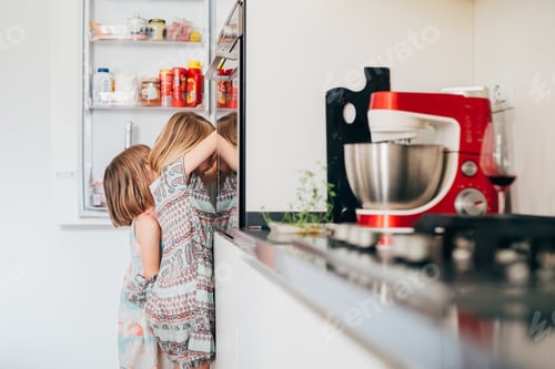 Preview: Two hungry female children irresistibly hungry searching for food in the fridge