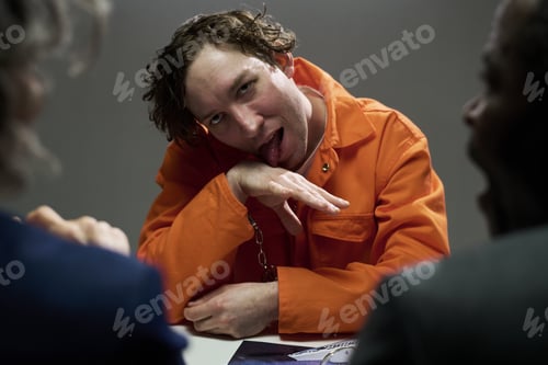 Preview: Expressing Defiance in Orange Jumpsuit while Seated