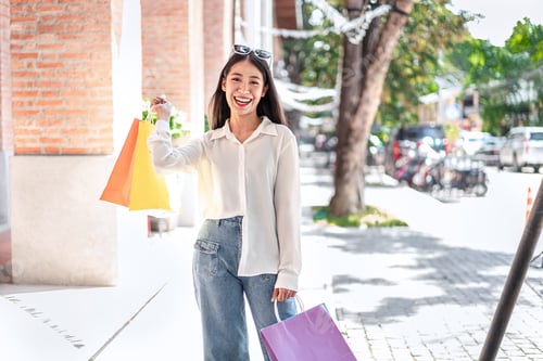 Preview: Beautiful girl wearing sunglasses happy smiling with holding shopping bags enjoying in shopping