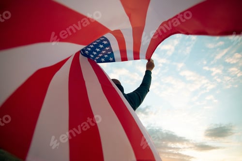 Preview: Man holding a waving american USA flag.