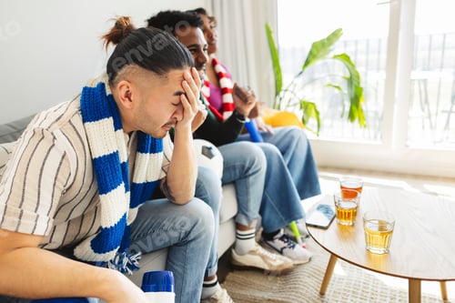 Preview: Disappointed sports fan watching soccer game at home