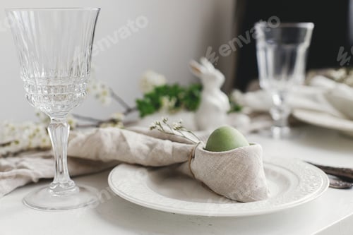 Preview: Easter egg in bunny napkin, plate , cutlery, flowers. Rustic Easter brunch table setting