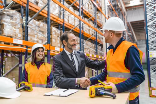 Preview: Entrepreneur shaking hands with worker in logistics warehouse