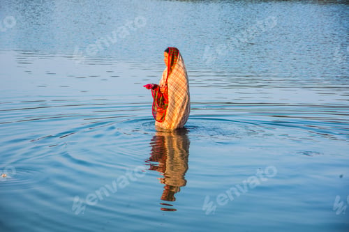 Preview: Traditionally dressed Indian woman pray into the river on Chhat Puja Festival.