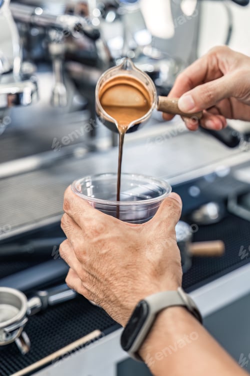 Preview: Barista pouring coffee from to plastic cup in coffee shop