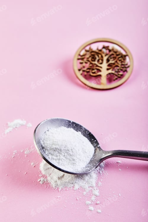 Visualização: Pó de colágeno em um fundo rosa. Ingestão extra de proteína.