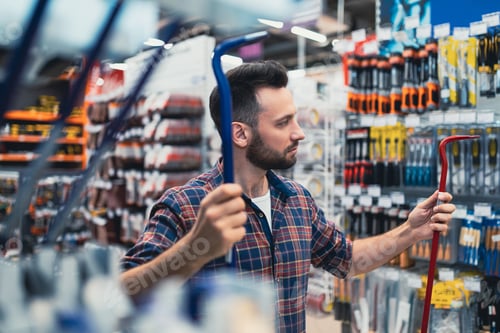 Preview: a male customer in a hardware store compares two nail pullers
