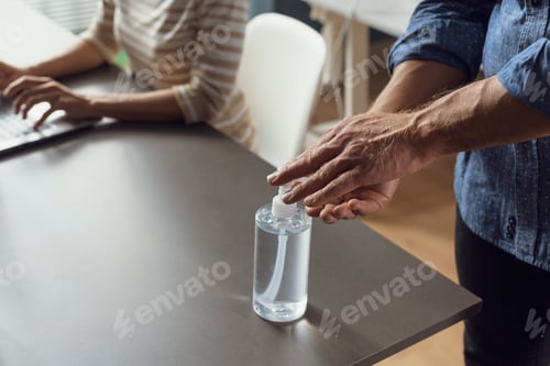 Vista previa: Business people working in the office and applying hand sanitizer on hands