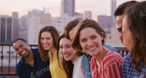 Preview: Group Of Friends Standing In A Line On Rooftop Terrace For Party With City Skyline In Background