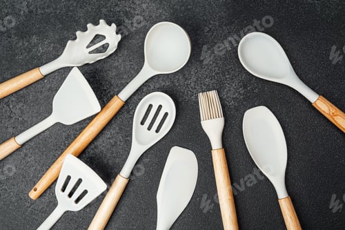 Preview: Colorful kitchen utensils arranged on a dark surface for cooking