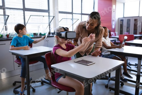Preview: African american female teacher teaching caucasian girl to use vr headset in the class at school