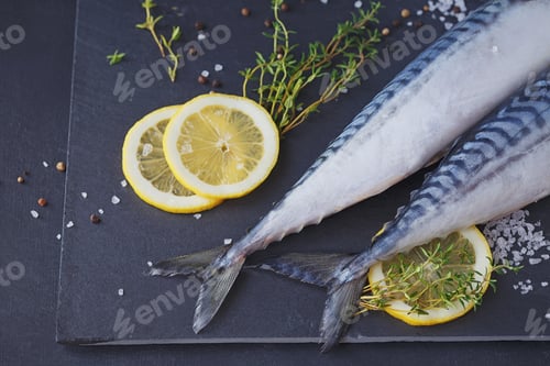 Preview: Fresh raw fish mackerel and ingredients for cooking on a dark background in a rustic style.