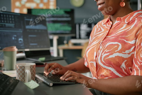 Preview: Young Adult Black Woman Smiling While Entering Data on Wireless Keyboard