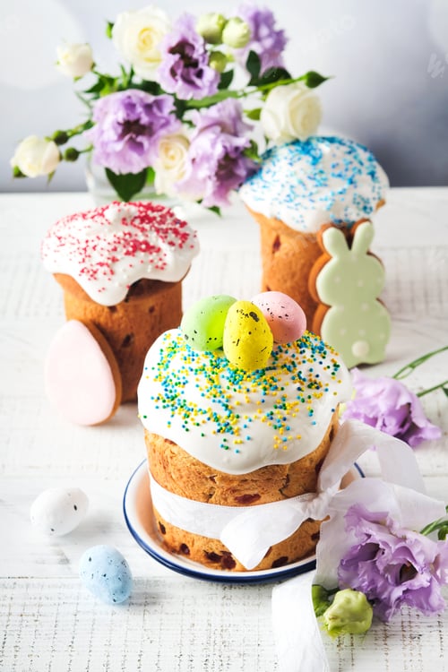 Preview: Traditional Easter sweet bread or cakes with white icing and sugar decor and quail eggs over white w