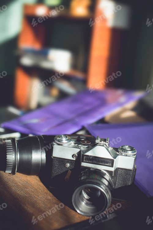 Preview: Retro photo camera on a wooden table. vintage style.