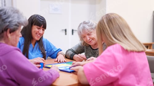Preview: Caregivers and seniors enjoying board game together in nursing home