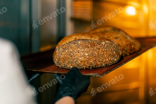 Preview: Close-up shot of hot freshly baked bread standing on a baking tray and being finished in the oven on