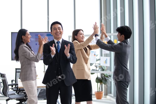 Preview: Asian business team celebrate corporate victory together in office.