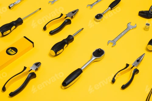 Preview: Yellow and black handy tools (pilers and screwdriver) isolated on yellow background.