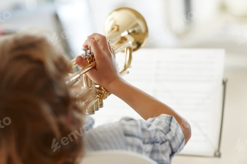 Preview: Hitting the high notes. Rearview shot of a little boy playing the trumpet.