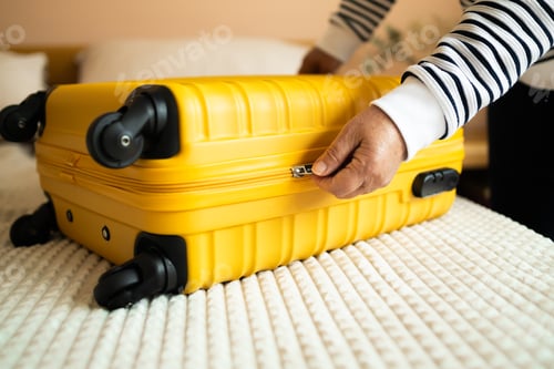 Preview: Close-up of senior male hands packing and locking bag for holidays trip. Female preparing travel