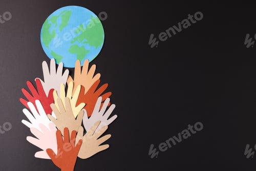 Preview: Paper cut out of multi coloured hands and globe with copy space on black background