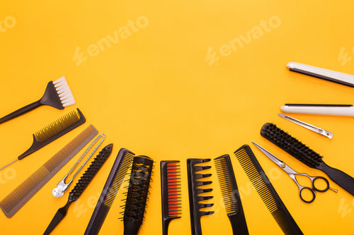 Preview: Hairdresser tools, accessories and combs on yellow background, top view.