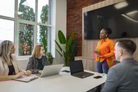 Preview: Group of People Sitting Around Table With Laptops