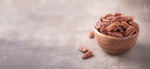 Preview: Pecan nuts in wooden bowl on wood textured background. Copy space. Superfood, vegan, vegetarian food