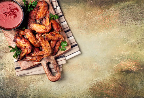 Preview: fried in the oven, chicken wings, with spices, tomato sauce, on a cutting board, gray background,