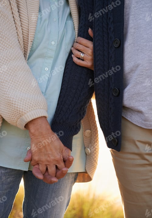 Preview: Committed through thick and thin. Cropped view of a senior couple holding hands.