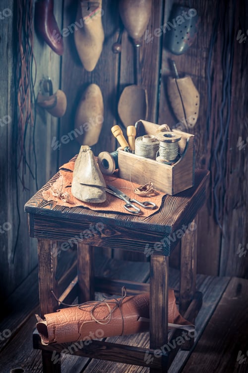 Preview: Rustic shoemaker workplace with shoes, laces and tools