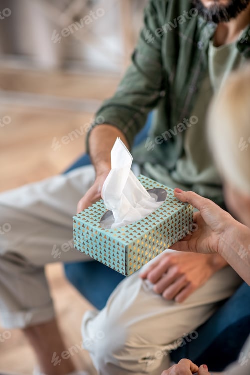 Preview: Close up of psychoanalyst giving pack of napkins to patient