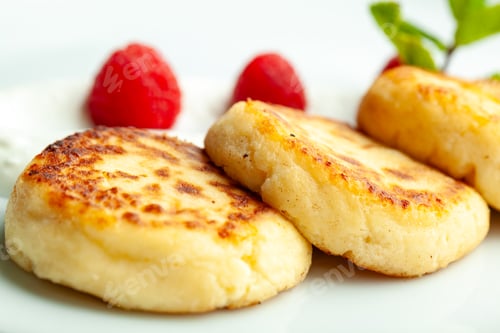 Preview: Cottage cheese pancakes with raspberries lying on white plate