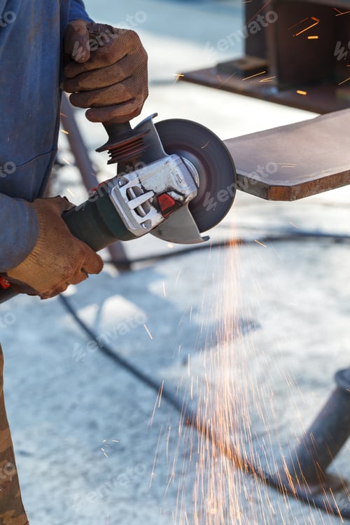 Preview: Worker cuts a metal structure with an electric flex