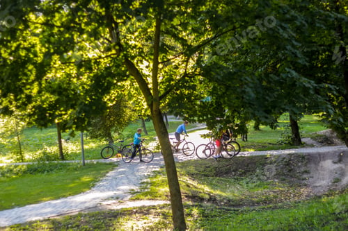 Preview: Closeup Kid boy with bicycle on a pump track park in sunset light. Asphalted bicycle race track, kid
